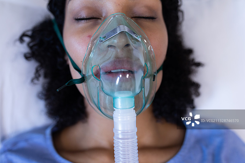 闭着眼睛在医院使用氧气呼吸机的非洲裔女病人图片素材