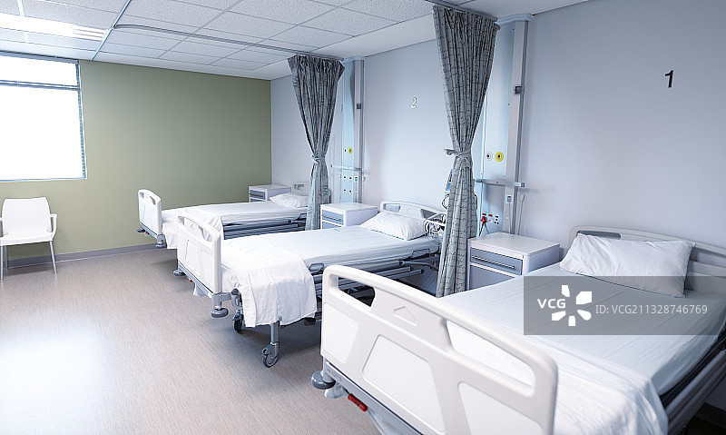 空旷的医院病房，配有三张病床图片素材