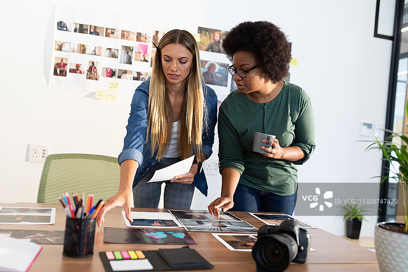 多元女性商业同事在会议室查看照片图片素材