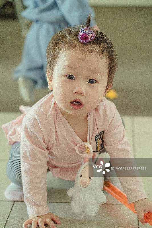蹲在地板上的女婴图片素材