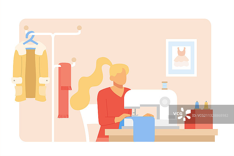 年轻的女裁缝在工作室使用缝纫机做衣服图片素材