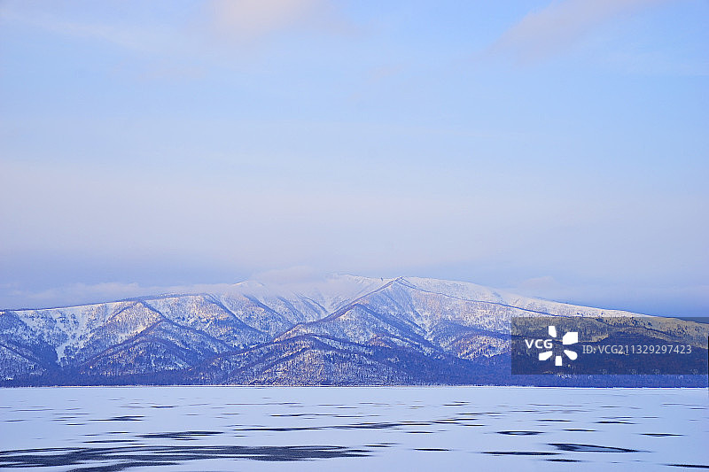 日本屈斜路湖边的低矮山岭被夕阳的余晖照耀着图片素材