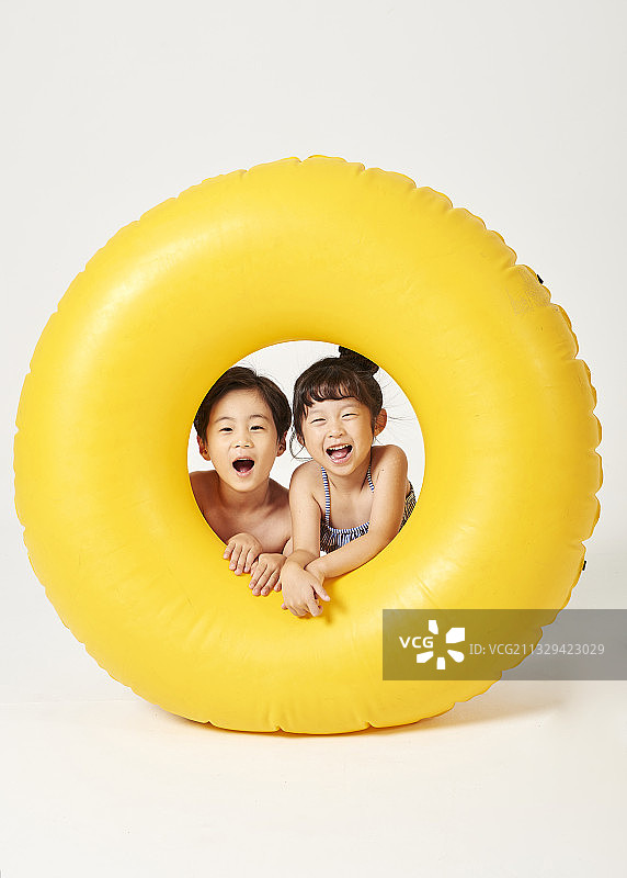 男孩和女孩抱着一个巨大的管子图片素材