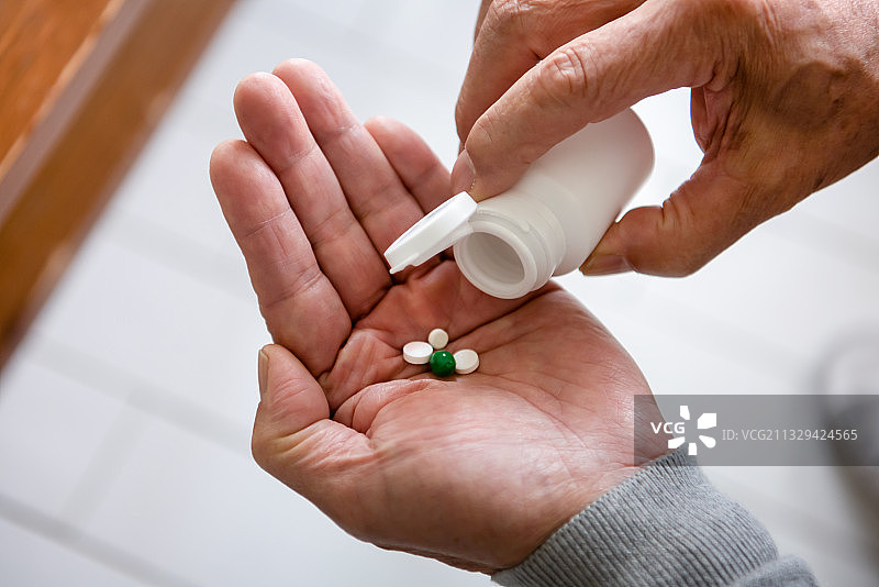 从瓶子里取药的人的特写图片素材