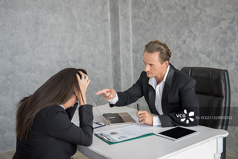领导者在办公桌旁指责女员工图片素材