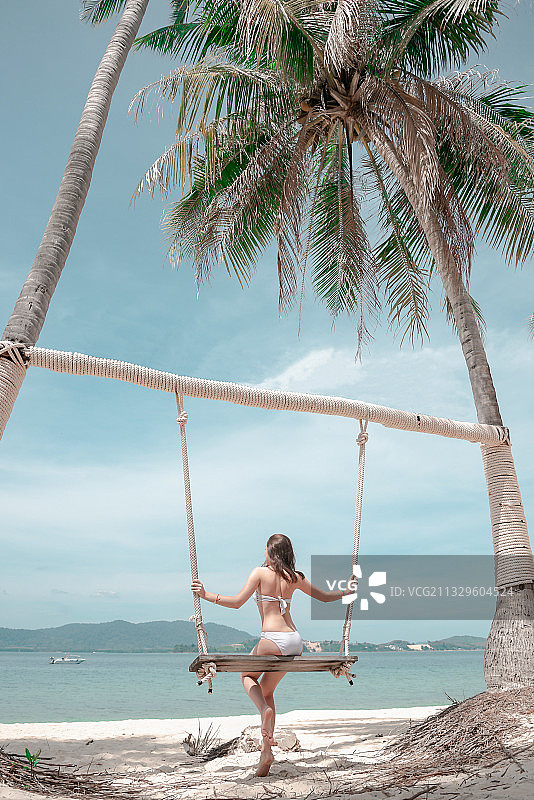 在海滩荡秋千的女人图片素材