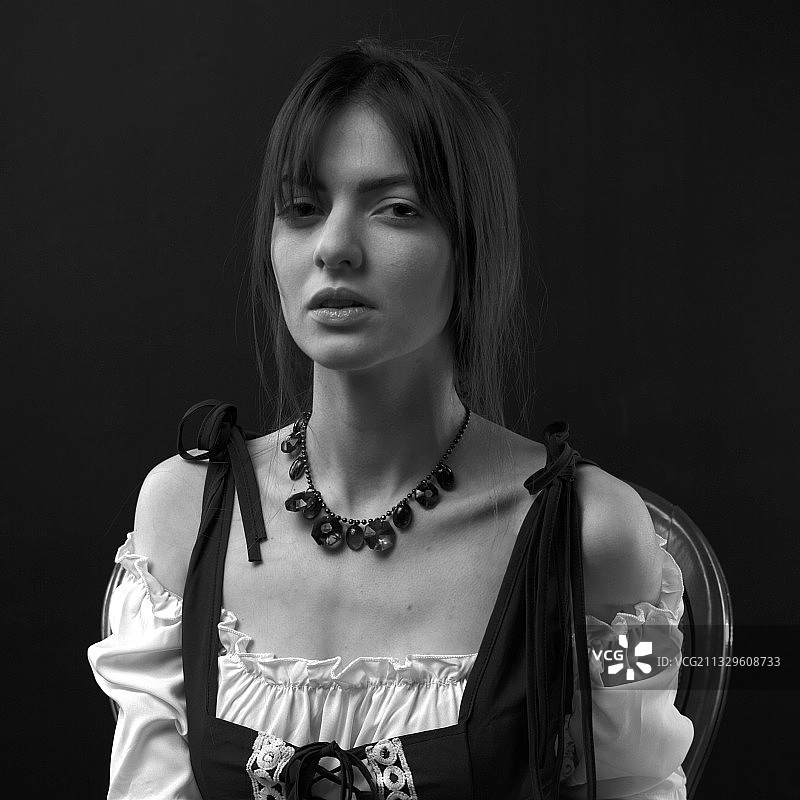 站在黑色背景前的年轻女子肖像图片素材