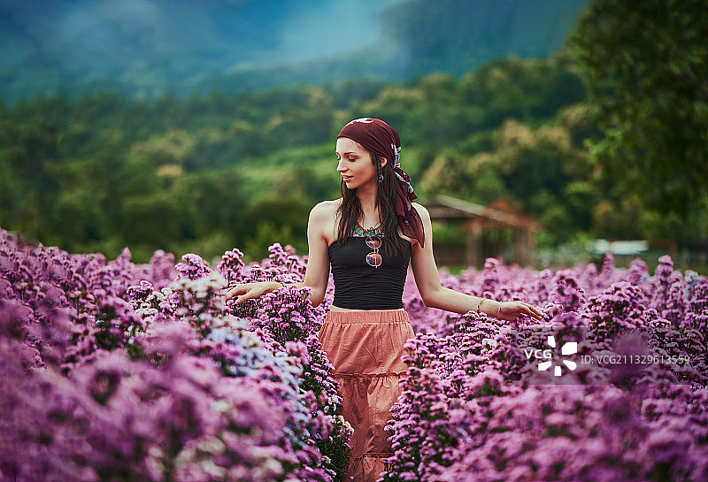 年轻女子站在泰国清迈的紫色花丛中图片素材