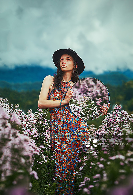 站在清迈田野开花植物旁的年轻女人图片素材