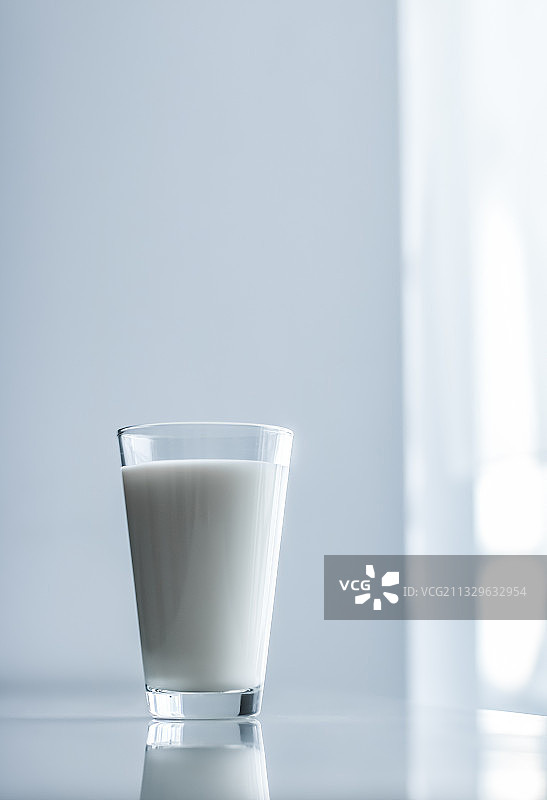 桌上玻璃杯中的牛奶特写图片素材