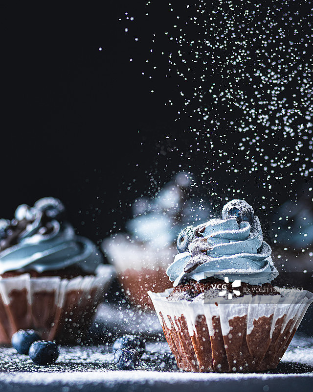黑色背景下的纸杯蛋糕特写图片素材