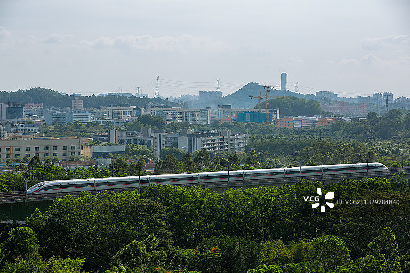 高铁从深圳罗田森林公园驶过，远处最高楼为长安地标图片素材
