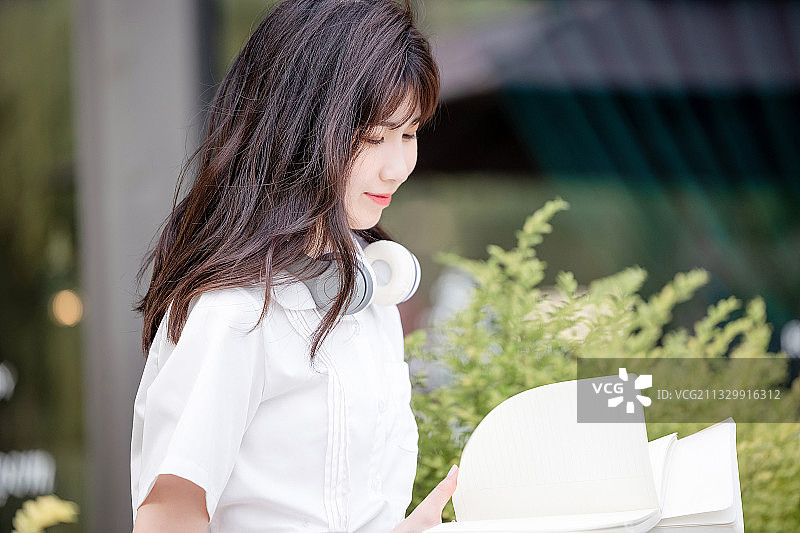 在户外，漂亮美丽的亚洲女大学生图片素材