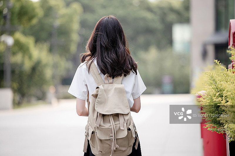 在户外，漂亮美丽的亚洲女大学生图片素材
