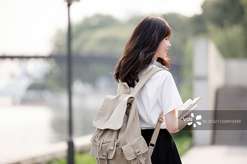在户外，漂亮美丽的亚洲女大学生图片素材