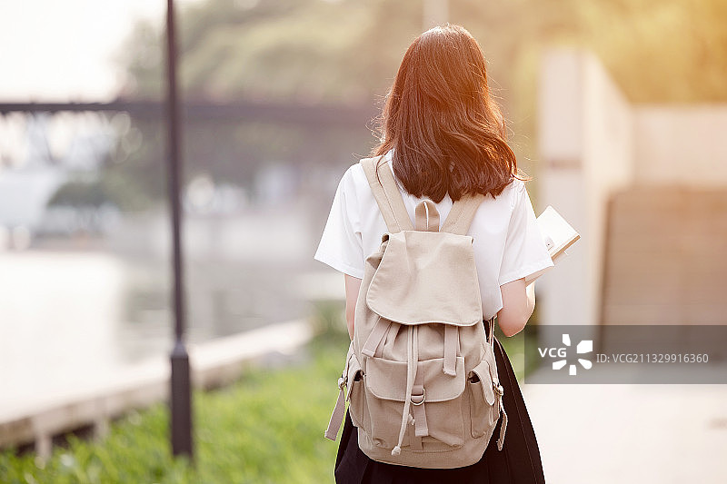 在户外，漂亮美丽的亚洲女大学生图片素材