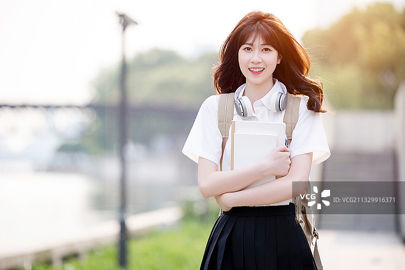 在户外，漂亮美丽的亚洲女大学生图片素材