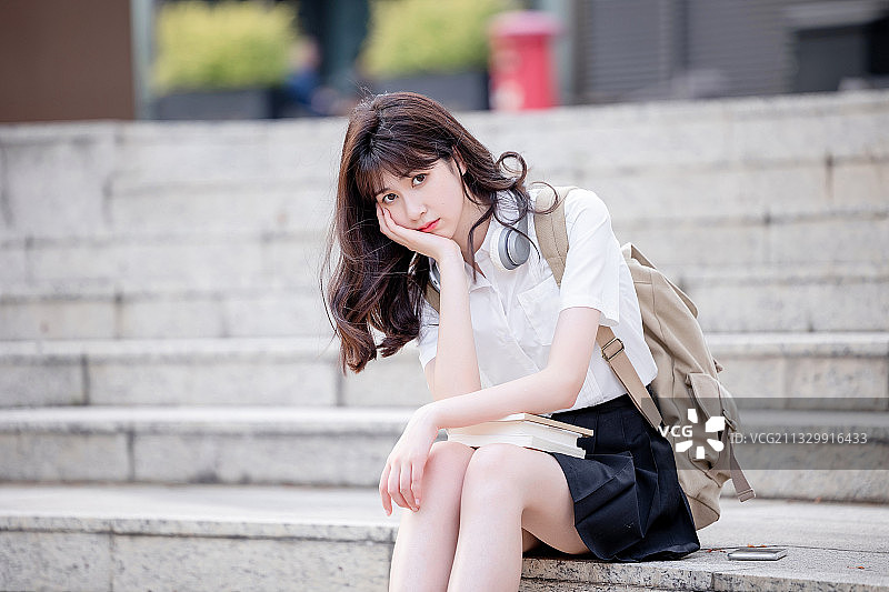 在户外，漂亮美丽的亚洲女大学生图片素材