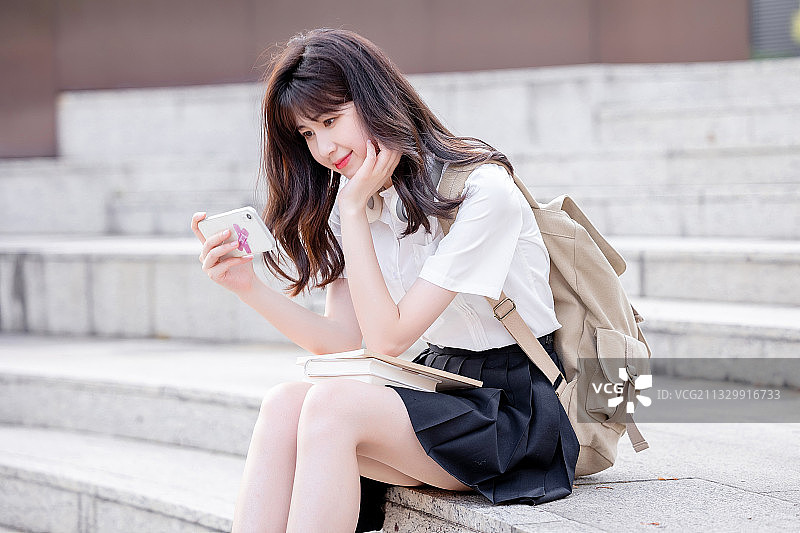 在户外，漂亮美丽的亚洲女大学生图片素材