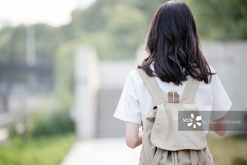 在户外，漂亮美丽的亚洲女大学生图片素材