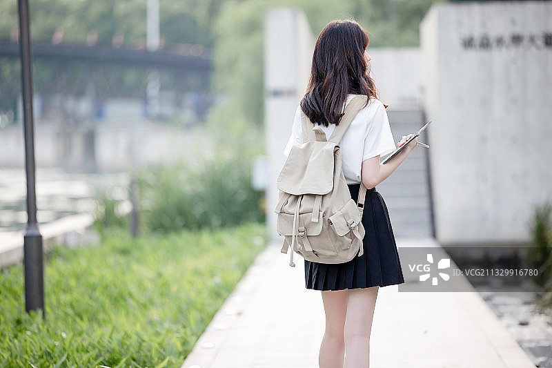 在户外，漂亮美丽的亚洲女大学生图片素材