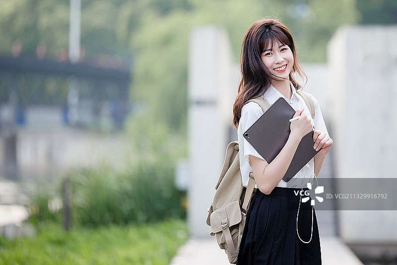在户外，漂亮美丽的亚洲女大学生图片素材