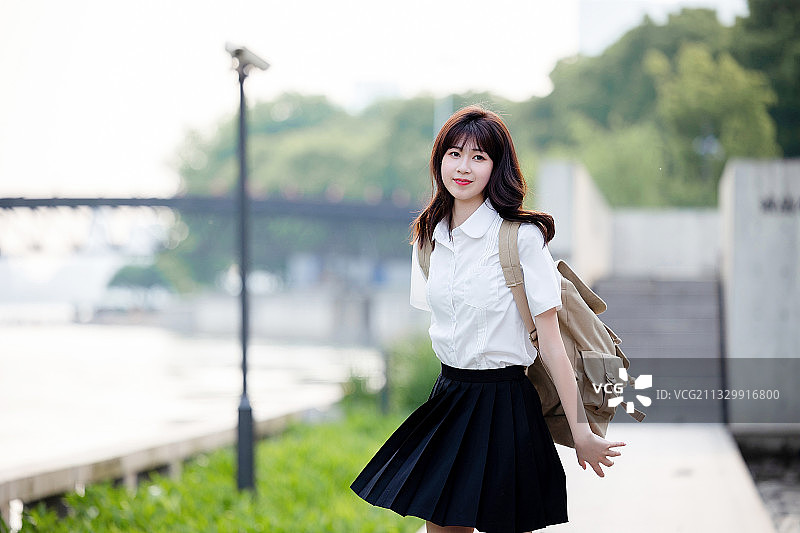 在户外，漂亮美丽的亚洲女大学生图片素材