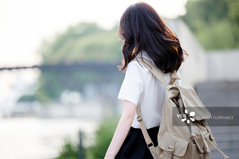 在户外，漂亮美丽的亚洲女大学生图片素材