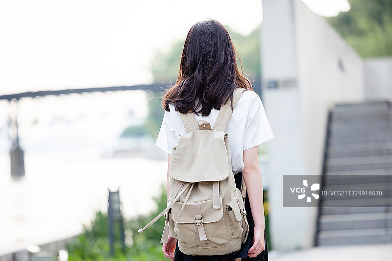 在户外，漂亮美丽的亚洲女大学生图片素材