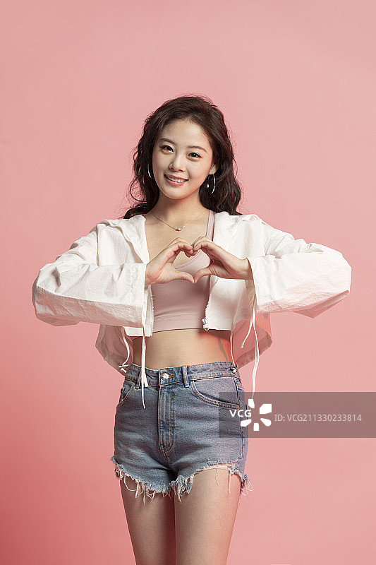 可爱的年轻女孩做心型手势图片素材