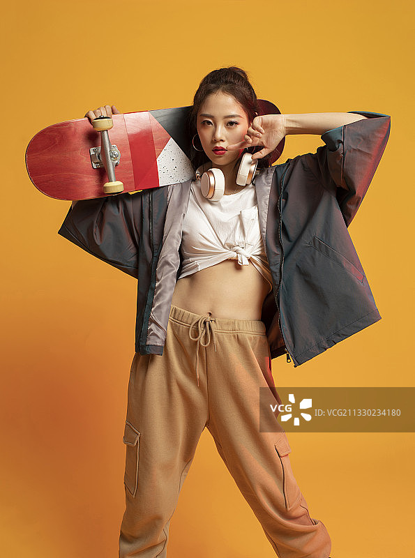 时尚的年轻女孩拿着滑板图片素材