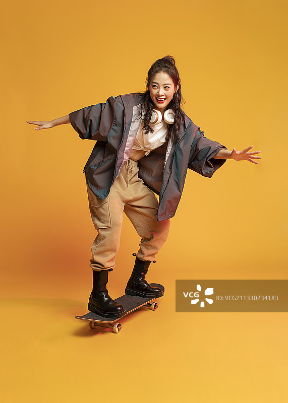 时尚的年轻女孩滑滑板图片素材
