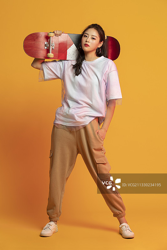 时尚的年轻女孩拿着滑板图片素材