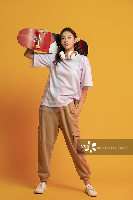 时尚的年轻女孩拿着滑板图片素材