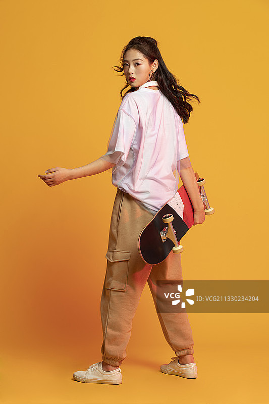 时尚的年轻女孩拿着滑板图片素材