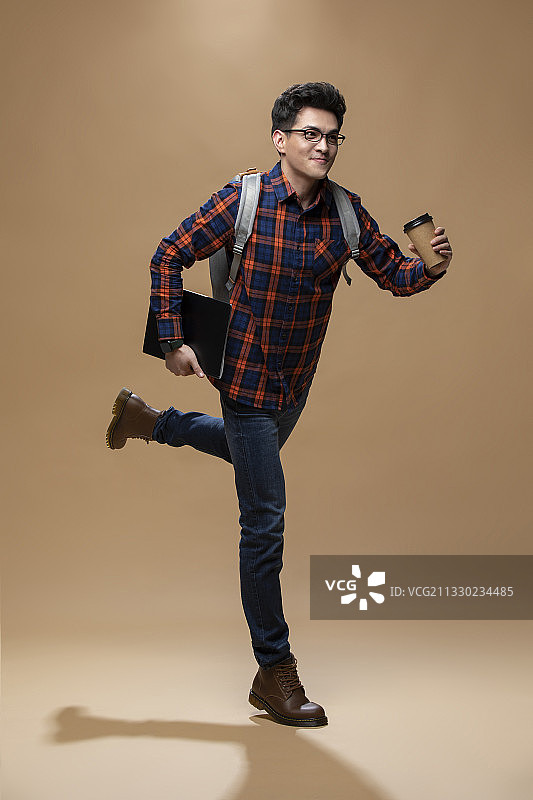 年轻程序员拿着笔记本电脑奔跑图片素材