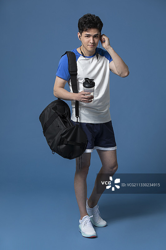 年轻运动员拿着一瓶水图片素材