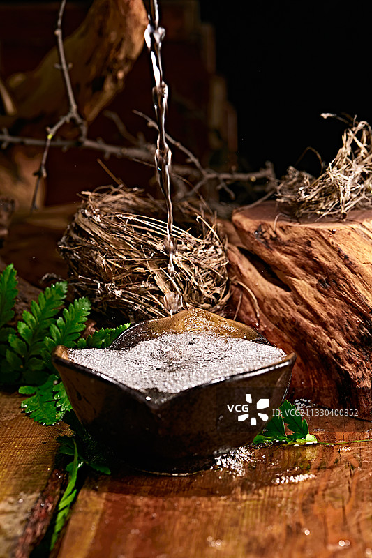 木板上摆放的酒具倒入清澈的白酒激起酒花图片素材