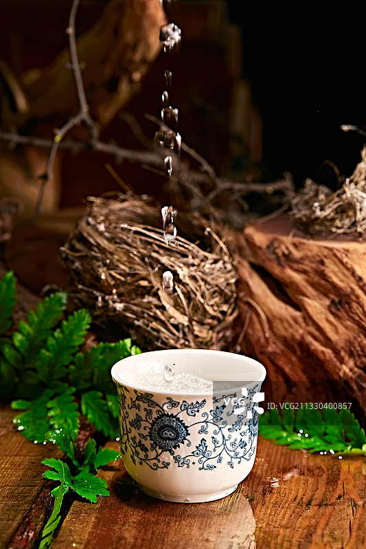 木板上摆放的酒具倒入清澈的白酒激起酒花图片素材