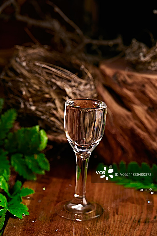 木板上摆放的酒具倒入清澈的白酒激起酒花图片素材