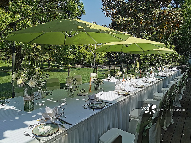 室外绿荫下摆放花瓶的餐桌图片素材