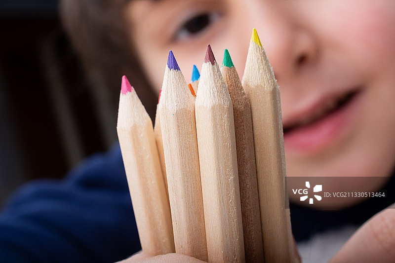 男孩拿着彩色铅笔特写图片素材