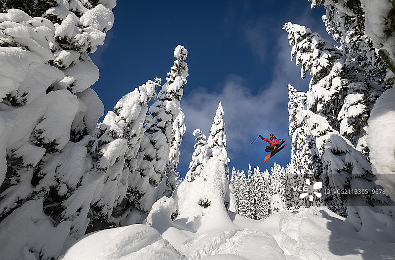 低角度的女人滑雪在白雪覆盖的山对天空，波克朱卡，斯洛文尼亚图片素材