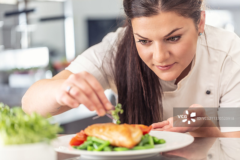 女厨师在专业厨房中健康食品的摆盘图片素材