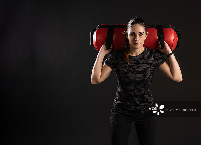 女人在黑色背景上进行健身训练图片素材