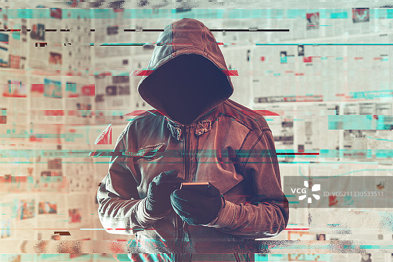在信息疫情概念中使用智能手机的蒙面黑客图片素材