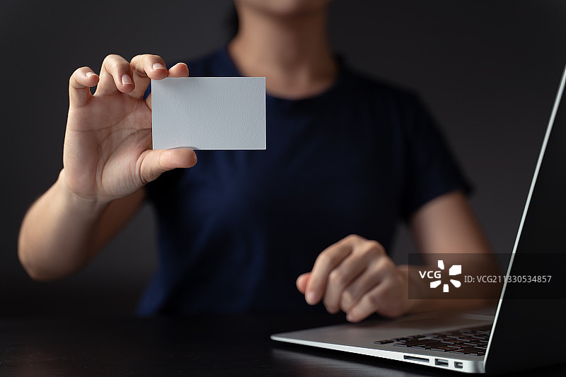 手持名片使用笔记本电脑图片素材