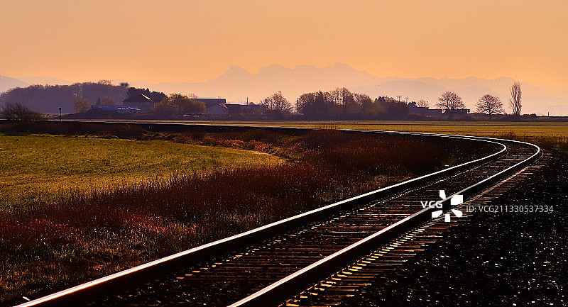 日落时分天空下的空旷铁轨图片素材
