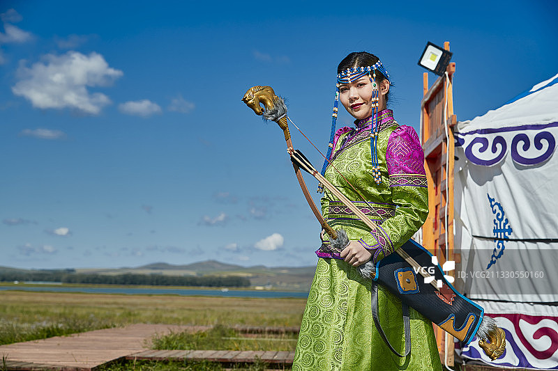草原湖畔身穿蒙族服饰身挎长弓的少女图片素材