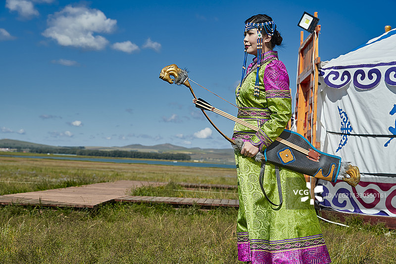 草原湖畔身穿蒙族服饰身挎长弓的少女图片素材